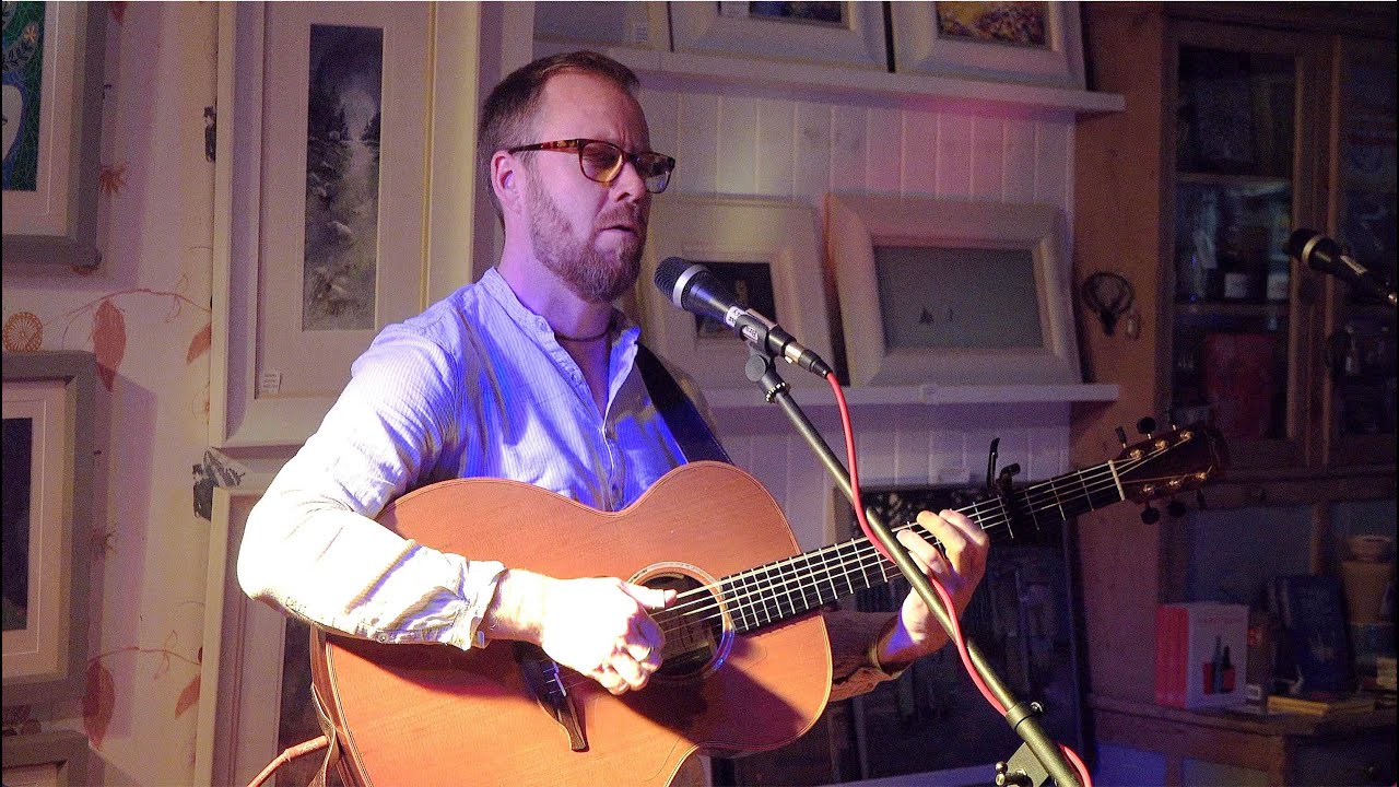 Scottish musician Ewan MacPherson performing his song 'Lay Your Dark Low' at Braemar Gallery in 2018