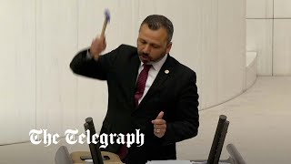 Turkish lawmaker smashes phone with hammer in parliament to protest social media bill