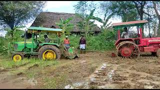 John deere tractor stuck in the mud with rotavetor and mahindra 475 tractor driver trying to pull.