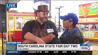 WIS' Judi Gatson speaks with professional blacksmith Trenton Tye during SC State Fair