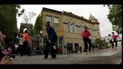 Ladies dancing a sassy dance in the street.