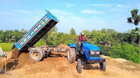 River soil digital unloading facility of hydraulic system of tractor unload on roadside soil hills