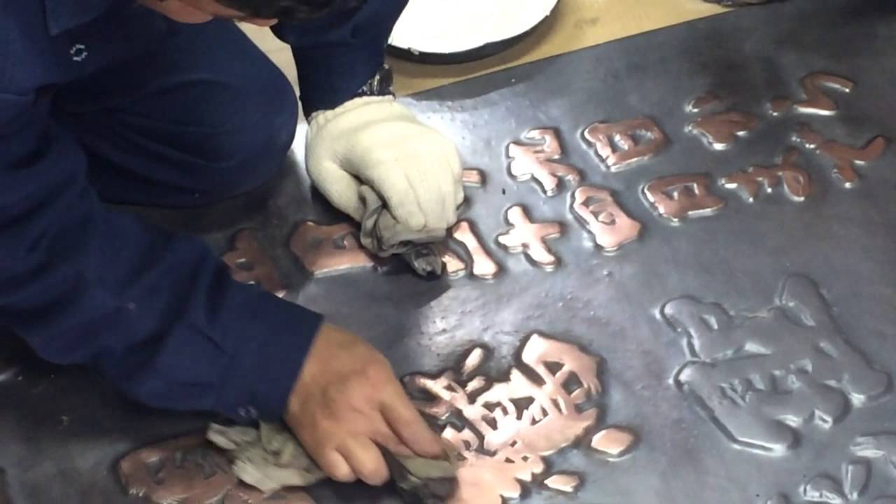 玉川堂が三条別院から以来された鎚起銅器の駒札の着色作業 - YouTube