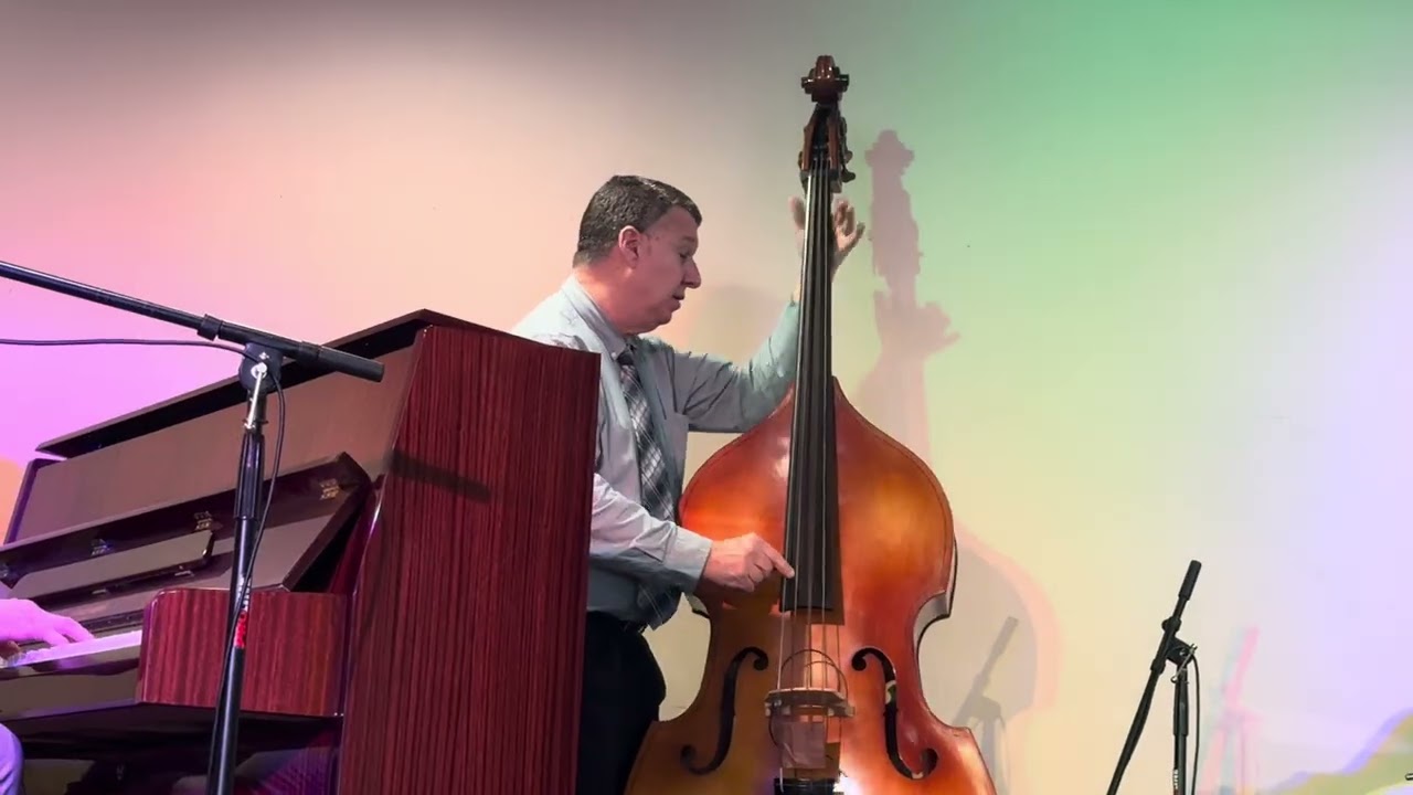 Grand piano bass and drums set up on stage for a jazz trio performance