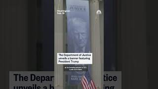 Justice Department unveils banner featuring Trump