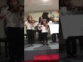 Clara Maria y Ernesto tocando violín y xilophono en una orquesta infantil