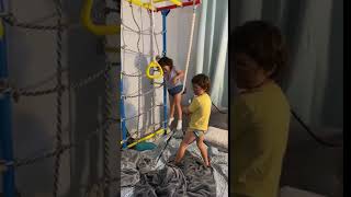 Brother Operates Swing Made Of Rope For Sister While Playing in Indoor Playground - 1112428 screenshot 5