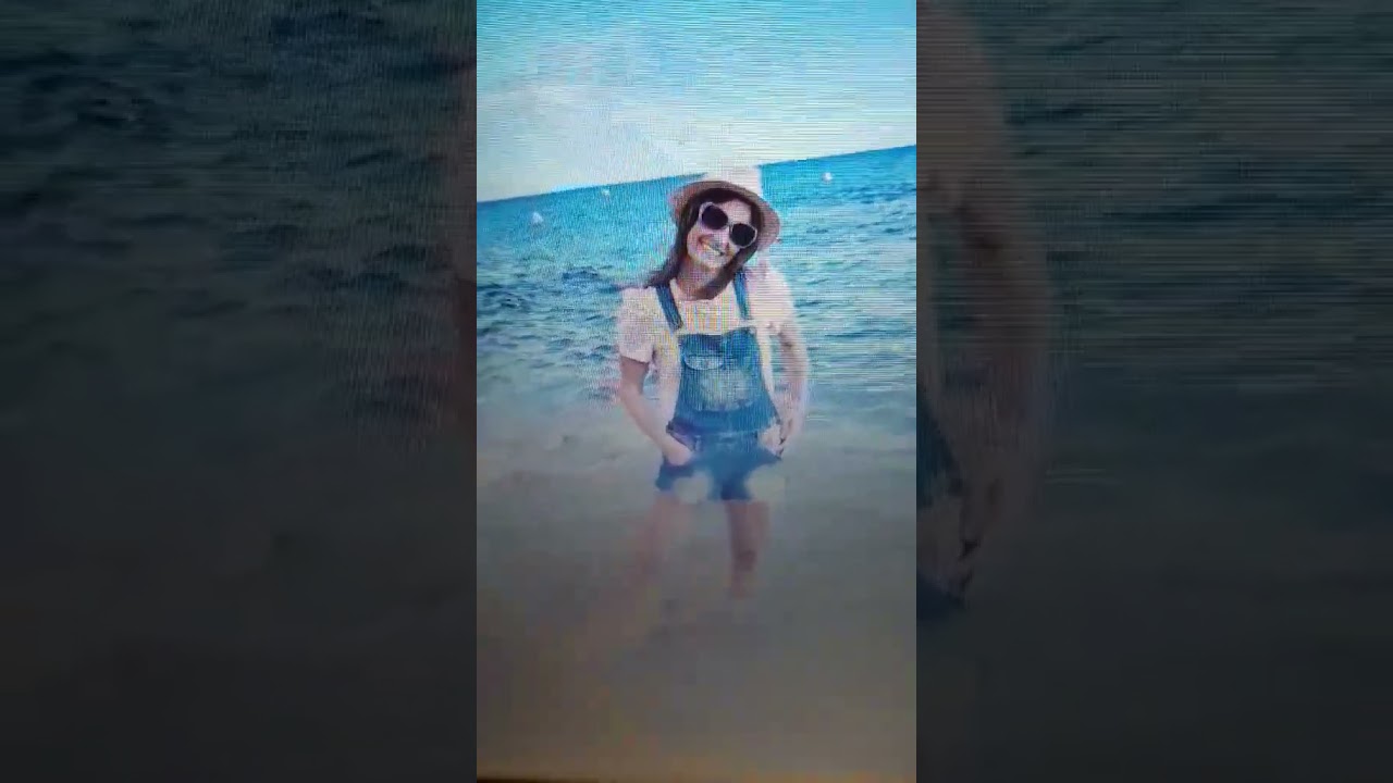 woman in sea wading barefoot after taking off her seeland wellies denim wet barelegs