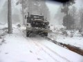 M813A2 Military Truck in heavy snow storm over a log