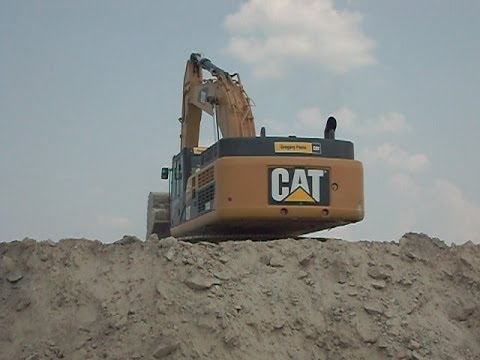 caterpillar-349l-excavator-loading-sand-on-volvo-40-ton-offroad-truck