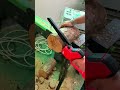 Cutting a circular tree log into thin slices using a small red electric chainsaw tool carefully