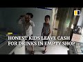 Trustworthy kids show banknotes to security camera while shopkeeper is away