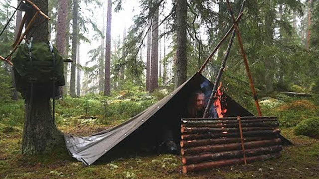 SOLO CAMPING AND BUILDING BUSHCRAFT SHELTER IN THE FOREST IN RAIN AND ...