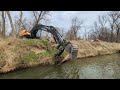 Excavator and a specialized pontoon boat working together on the river wet and wild