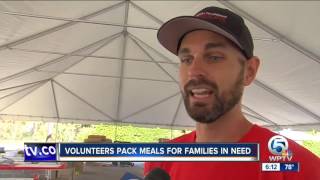 Volunteers prepare meals to donate for needy local families and ones across the world