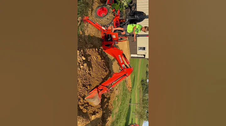 Kid operates Kubota backhoe