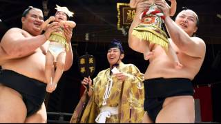Sumo wrestlers hold screaming babies aloft in ancient crying contest