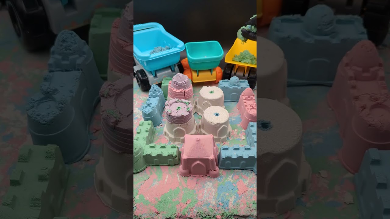 Bunte Sandburg abbauen und auf LKWs laden