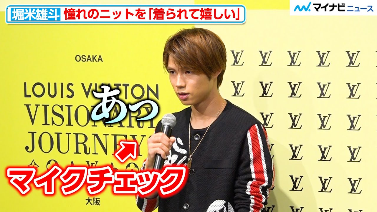 Skateboarder Yuto Horigome modestly checks the microphone, smiles