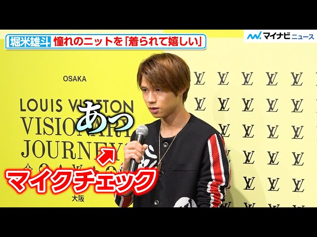 Skateboarder Yuto Horigome modestly checks the microphone, smiles