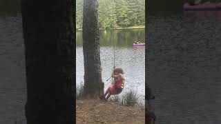 Boy swings from rope swing and bumps leg on tree