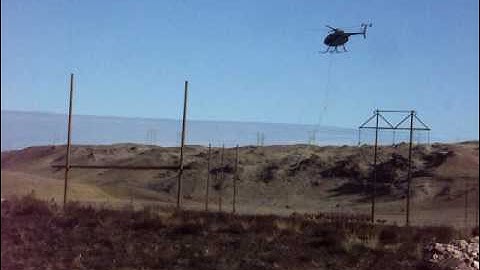 Helicopter stringing cable on Hughes Transmission Project