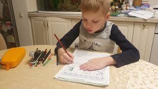 Дима учится писать букву "К".