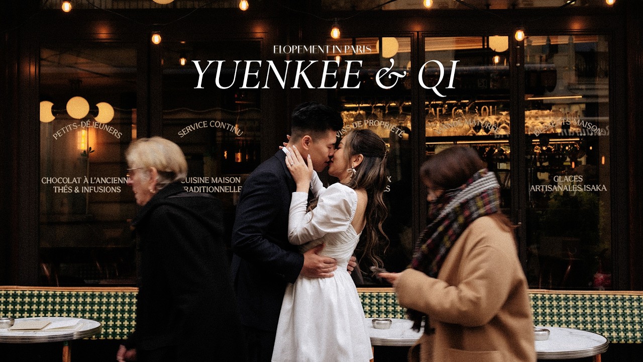 Bride and groom kiss outside a Paris café as pedestrians pass under warm window lights