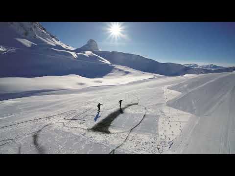 Artist Saype reveals "Encordés," his new ephemeral work painted on the snow-covered slopes of the French Alps for the 20th anniversary of the Paradiski ski area