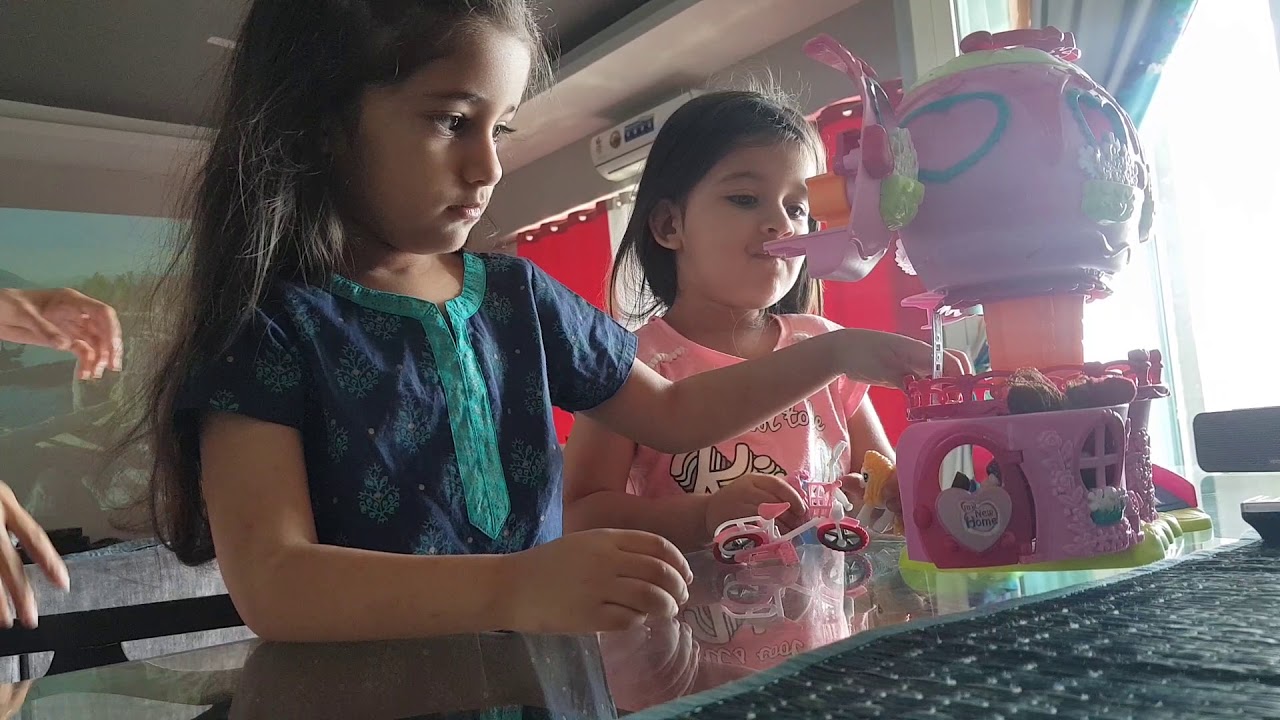 Bella and Vienna playing with their doll house