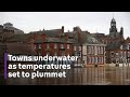 UK flooding: towns underwater as temperatures set to plummet