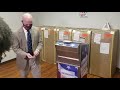 Board of Registrars Chairman Colin McRae demonstrates use of absentee ballot box