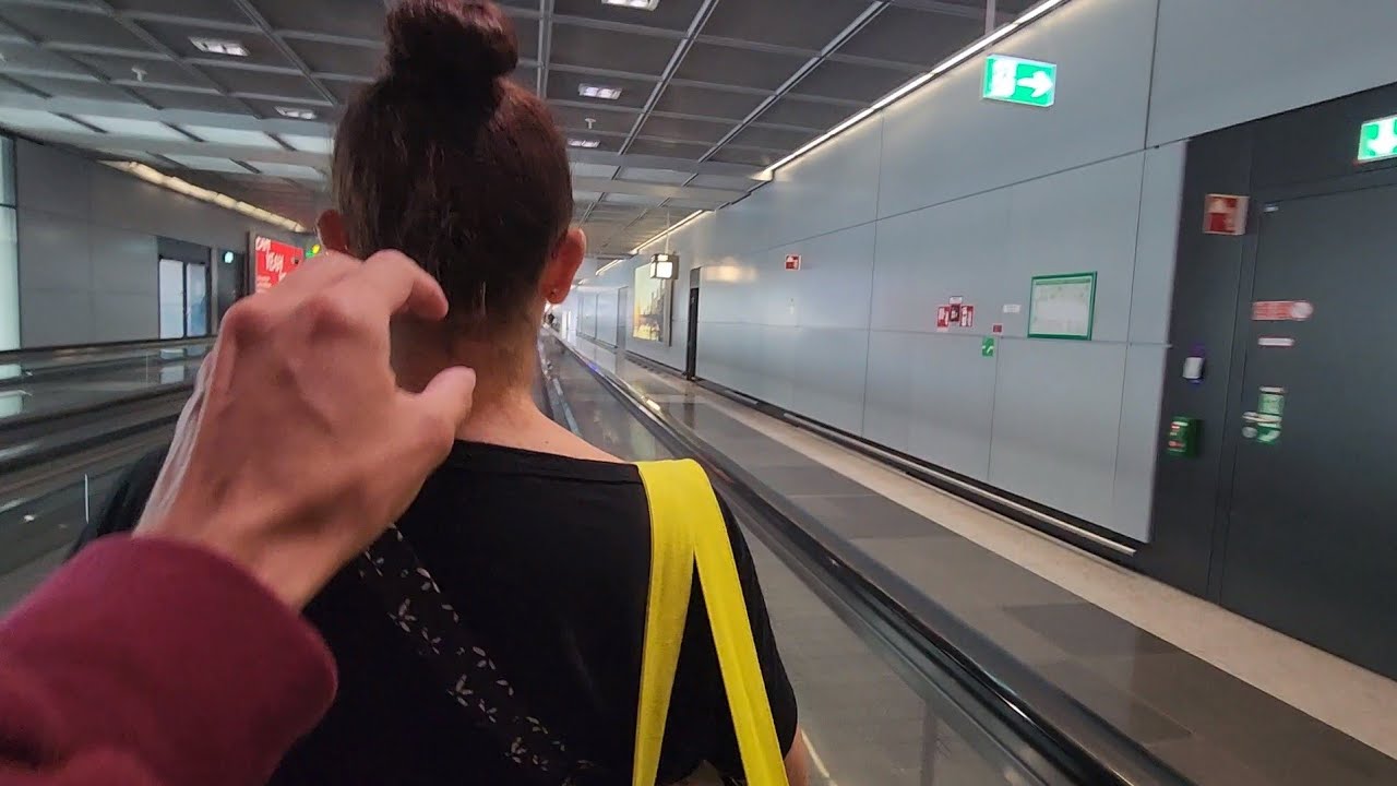 me tickling Angie's neck on moving walkway at Frankfurt Airport in Germany (May 9th, 2023)