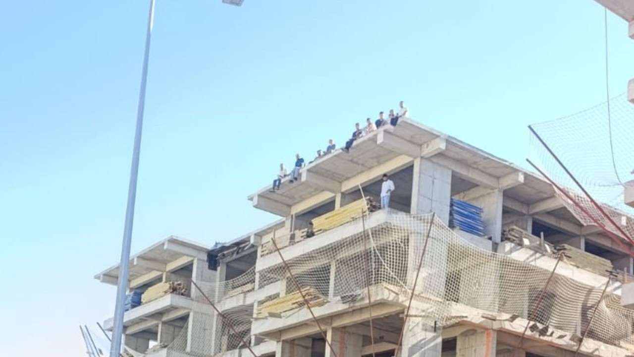 Besni’de maaşlarını alamayan inşaat işçileri çatıya çıkarak eylem yaptı