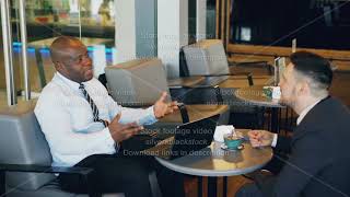 Two multiracial businessmen in formal clothes smiling, gesturing and discussing their startup in