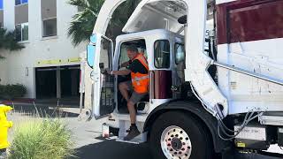 M236 repainted McNeilus front loader dumping trash dumpsters late in the afternoon