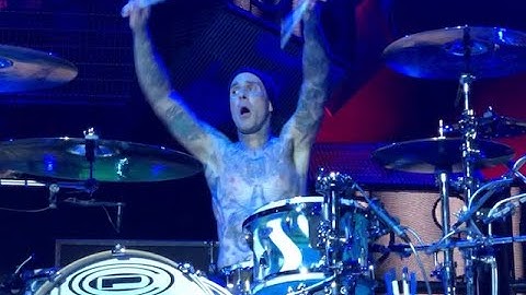 Travis Barker drumming in an upside down cage