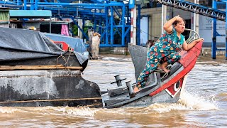     A Vietnamese Woman Steering Her Boat Through Busy River Traffic