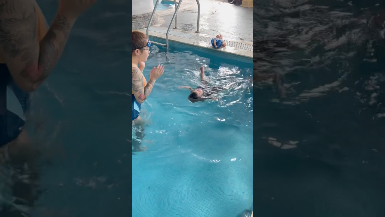 The baby swims with his mother and siíter. 