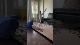 Boy hits exercise ball with plastic bat and accidentally hits little brother on his face