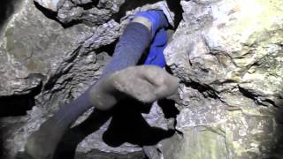 Caver Rick Hunter squeezing through the cave tunnels