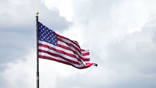 Stock Video - American Flag waving in slow motion against a cloudy sky
