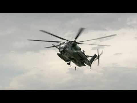 U.S. Marines use CH-53E Super Stallion to perform External lift of Harrier Jet.
