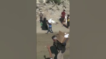 Palestinians rush to grab aid from trucks moving through Gaza