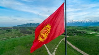 Флаг Кыргызстана и зелёные холмы