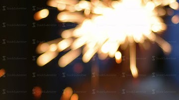 Firework sparkler burning in boy hands macro