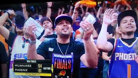 Guy Counting $100 Bills at NBA Finals While Giannis shoots free throws.