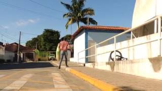 A man crashes a bicycle beside a rail outdoors