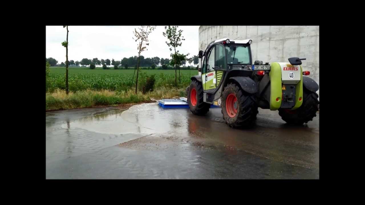 Traktor Anbaubesen der Marke KehrFix und einem Claas Scorpion auf der Biogasanlage