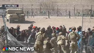 Migrants seen tearing down barrier at border